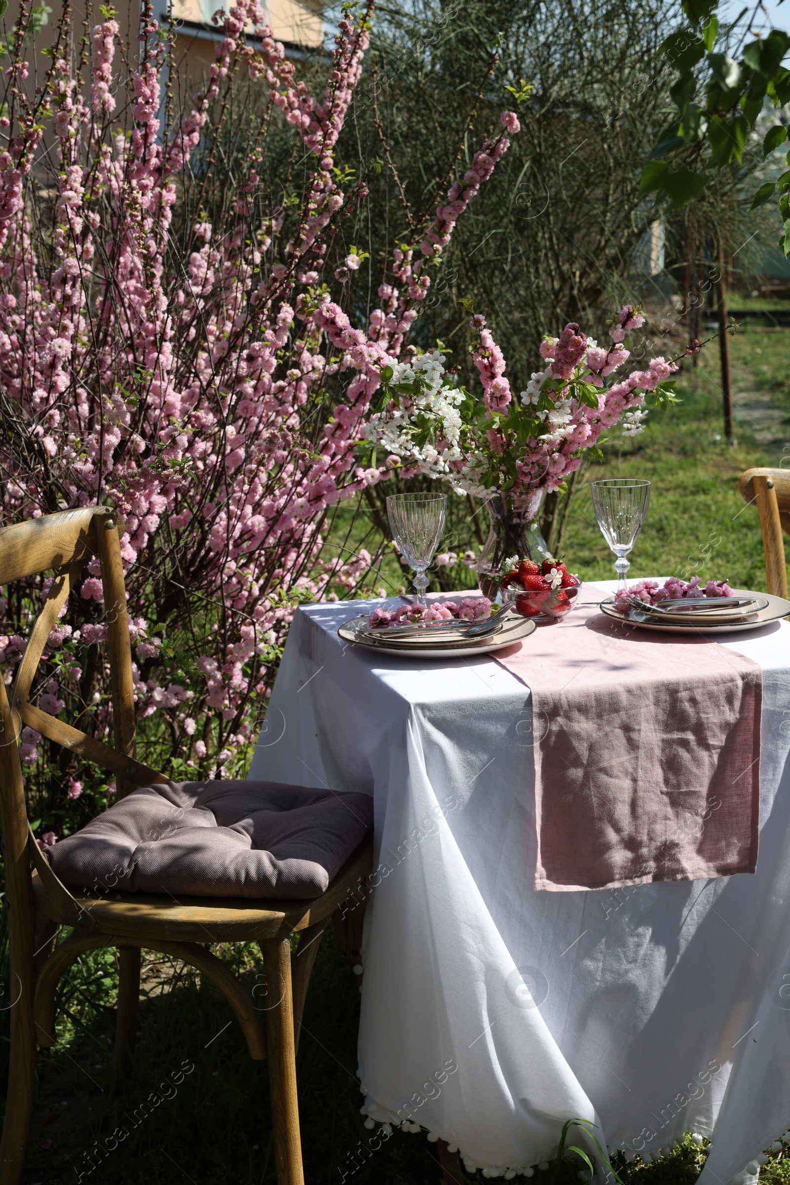 Photo of Stylish table setting with beautiful spring flowers in garden