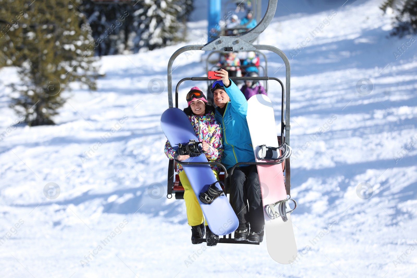 Photo of Couple taking selfie while lifting at mountain ski resort. Winter vacation