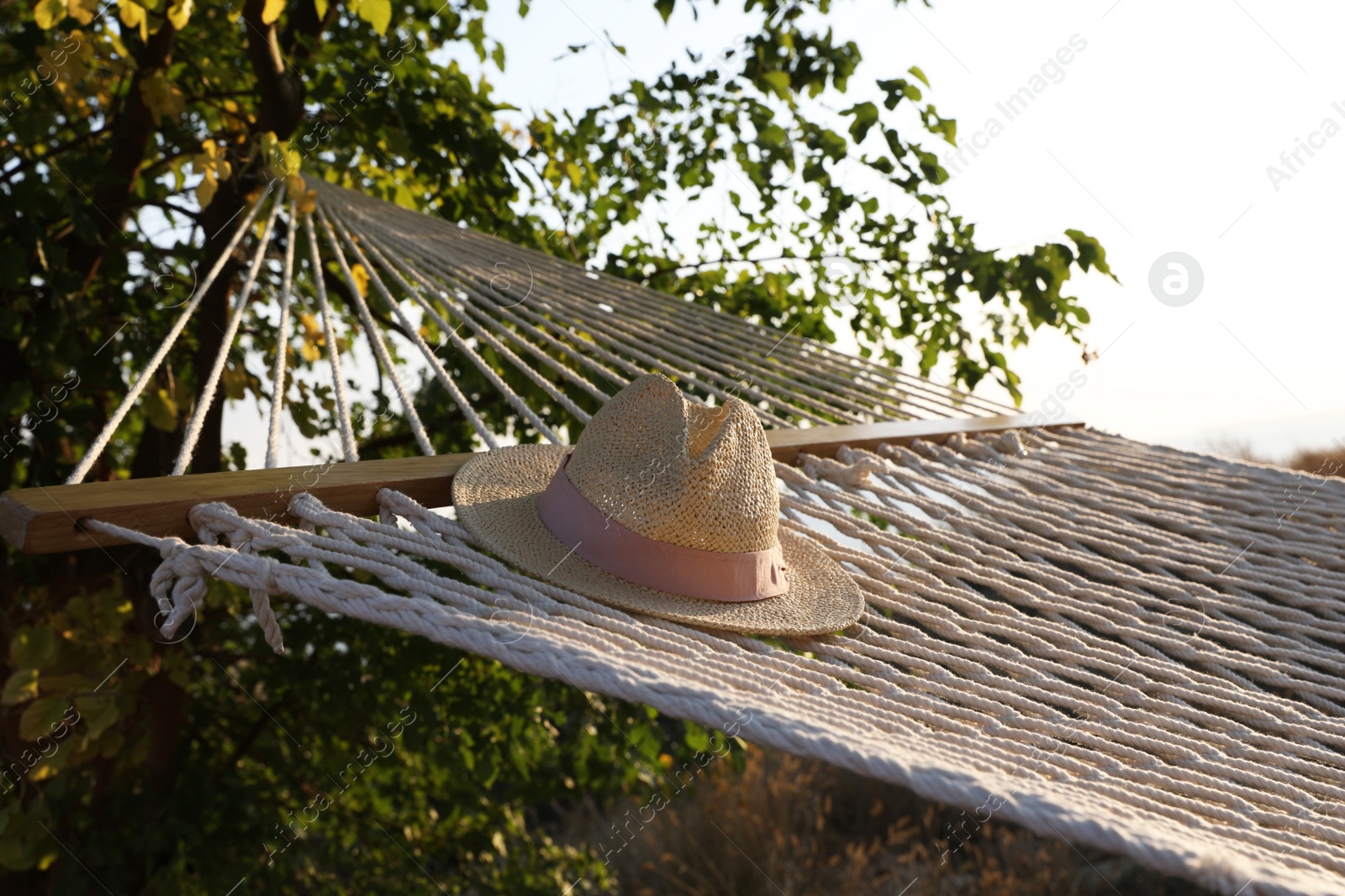 Photo of Hammock with hat hanging outdoors. Time to relax