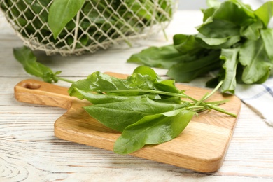Photo of Fresh green sorrel leaves on white wooden table, closeup