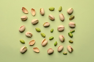 Photo of Composition with organic pistachio nuts on color background, flat lay
