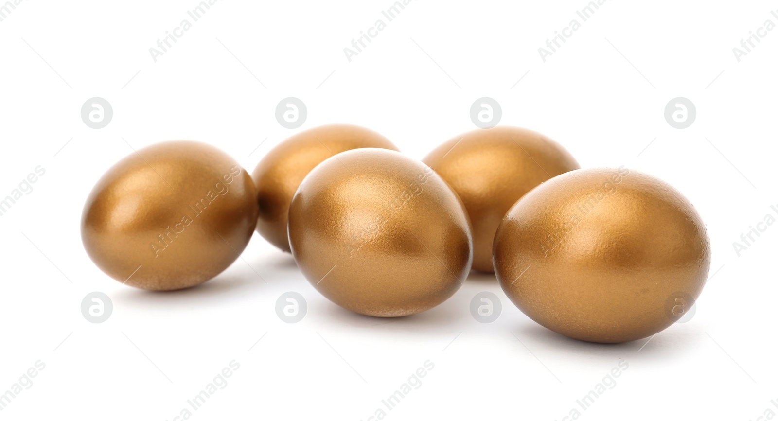 Photo of Many shiny golden eggs on white background