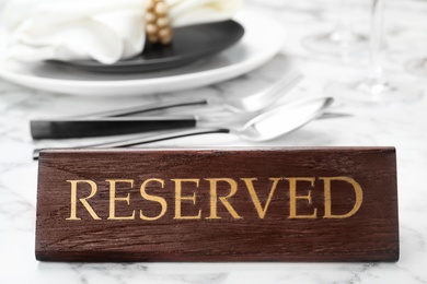 Table setting with RESERVED sign in restaurant