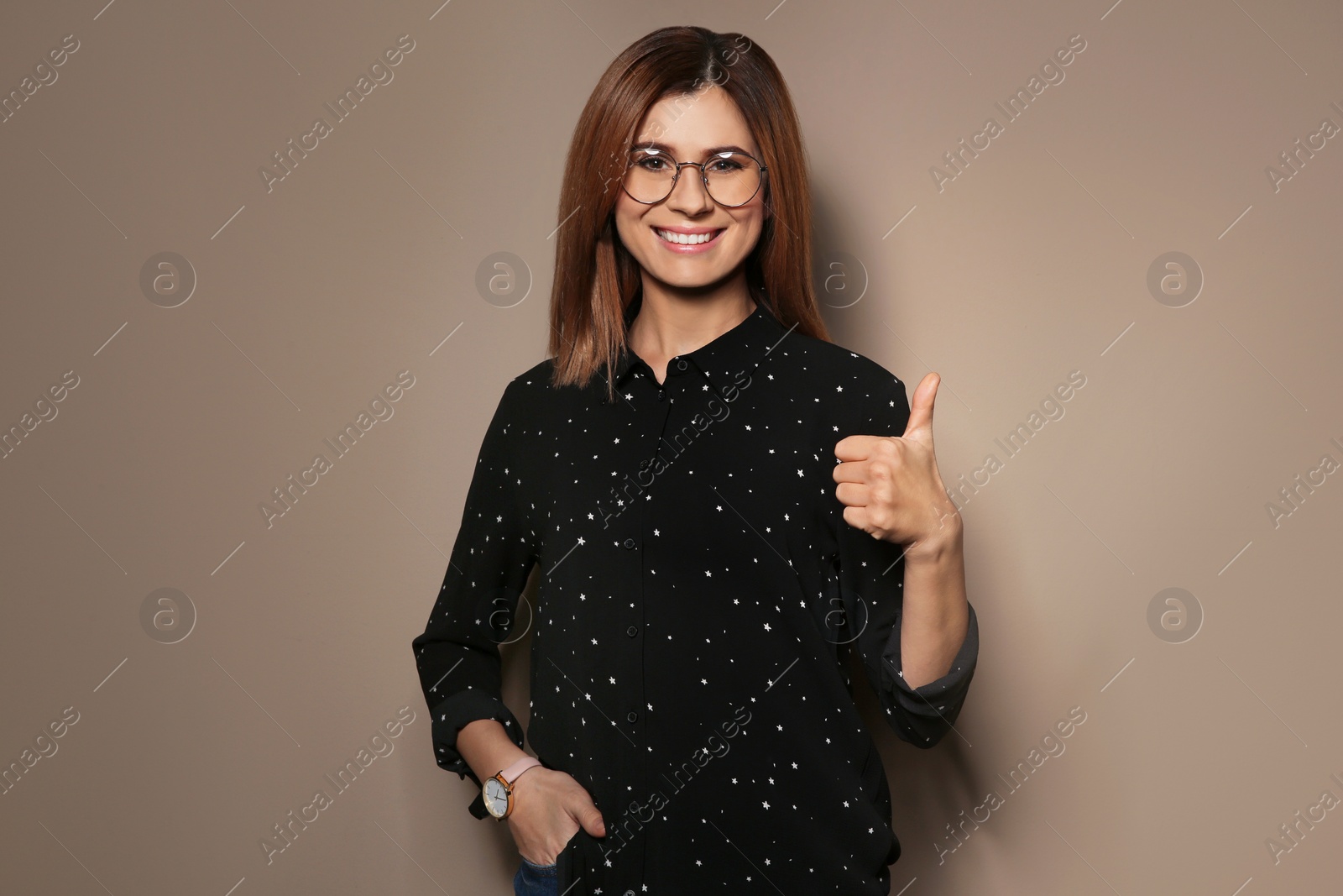 Photo of Woman showing THUMB UP gesture in sign language on color background