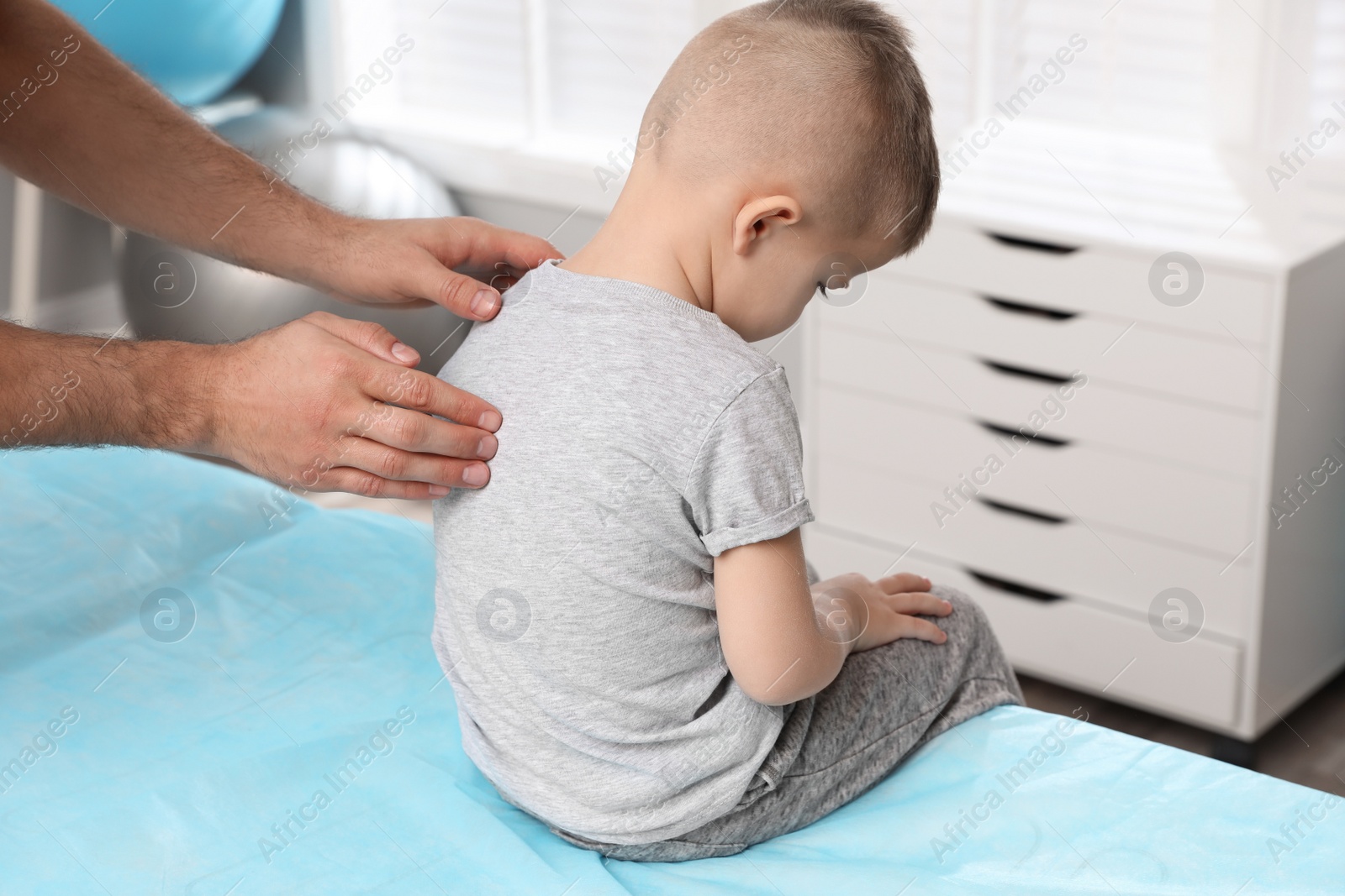 Photo of Orthopedist examining child's back in clinic, closeup. Scoliosis treatment