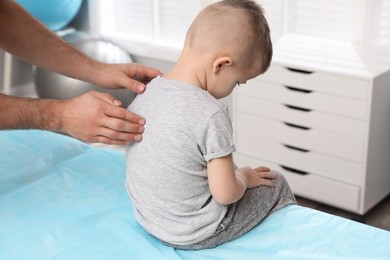 Orthopedist examining child's back in clinic, closeup. Scoliosis treatment