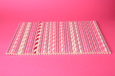 Many paper drinking straws on pink background