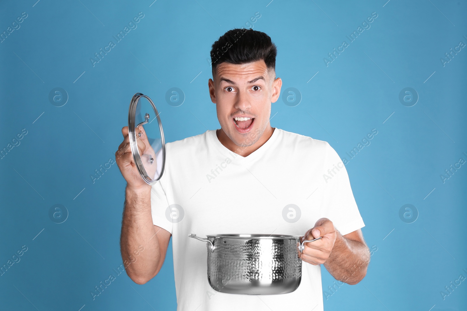Photo of Surprised man with pot  on light blue background
