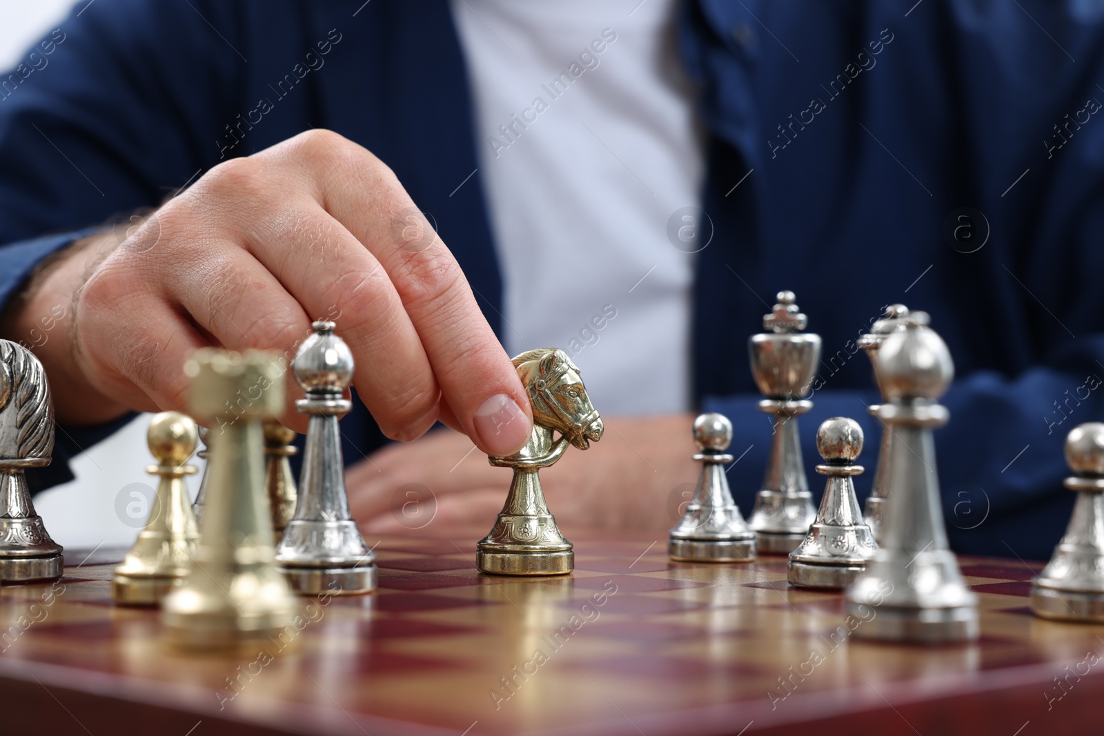 Photo of Man moving knight on chessboard, closeup view