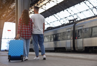 Photo of Long-distance relationship. Beautiful couple walking on platform of railway station, back view with space for text