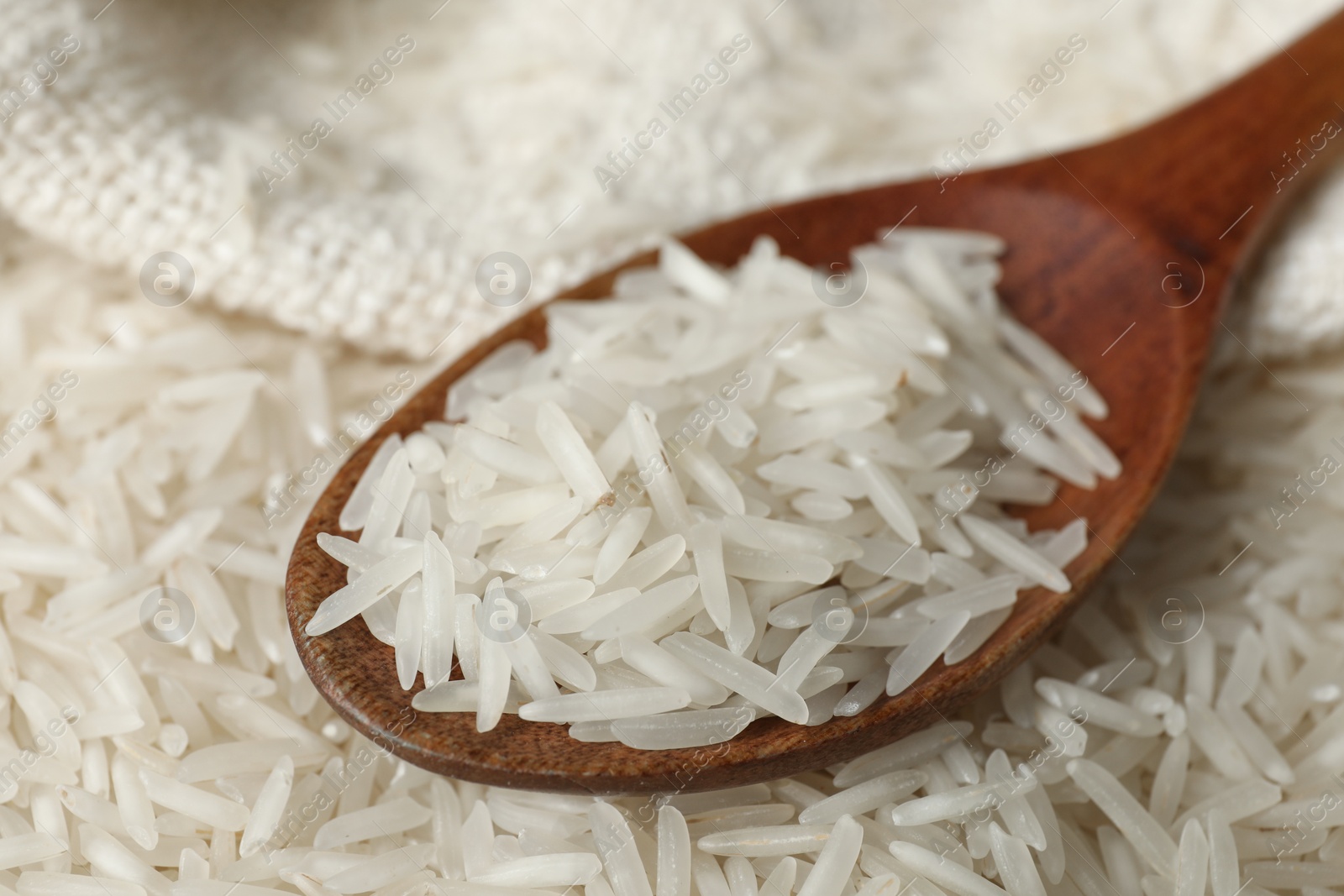 Photo of Raw basmati rice and spoon, closeup view