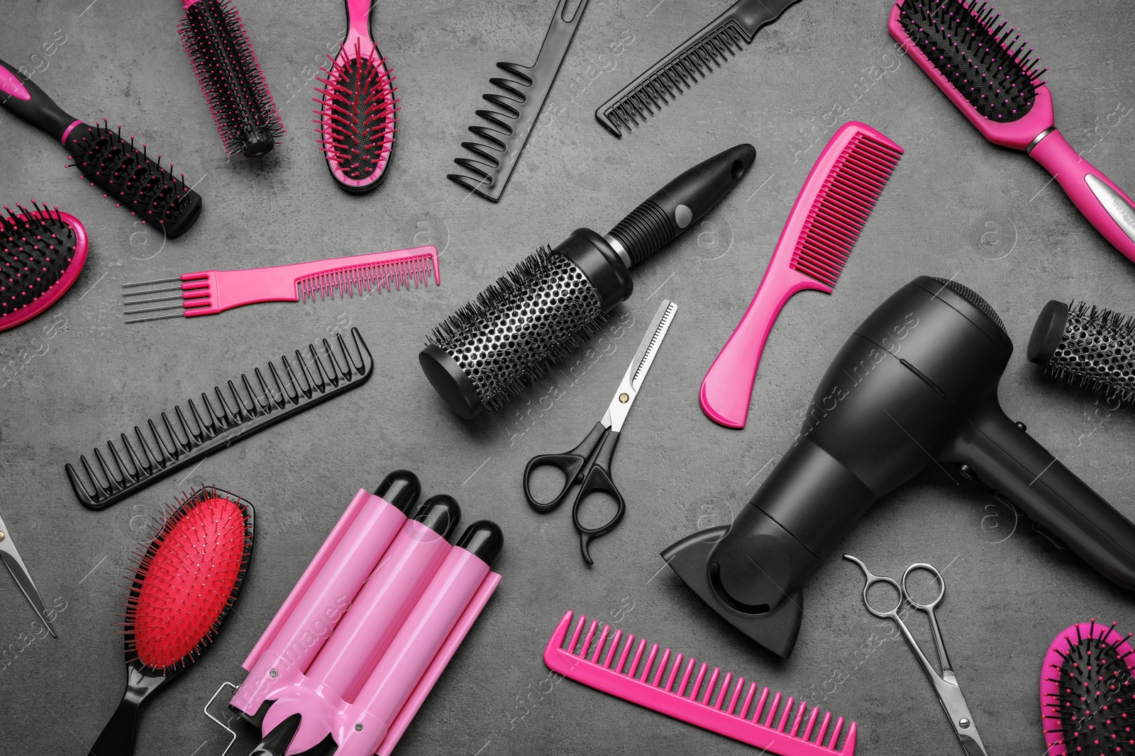 Photo of Flat lay composition of different professional hairdresser tools on dark grey table