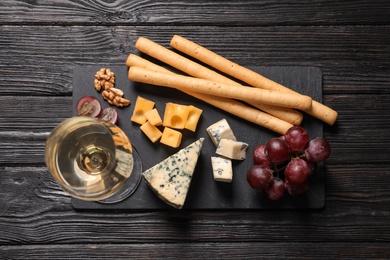 Photo of Flat lay composition with different types of delicious cheese on slate board