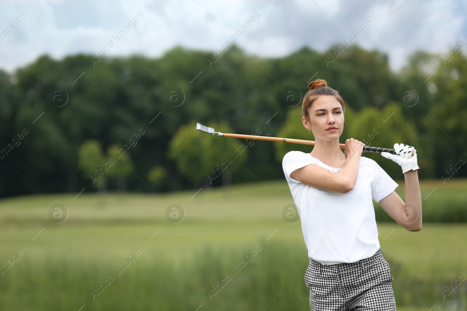 Photo of Woman playing golf on green course. Sport and leisure