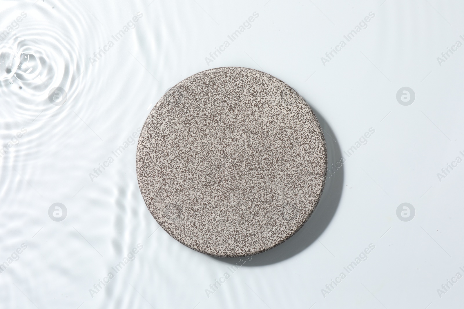 Photo of Presentation for product. Stone podium in water on white background, top view