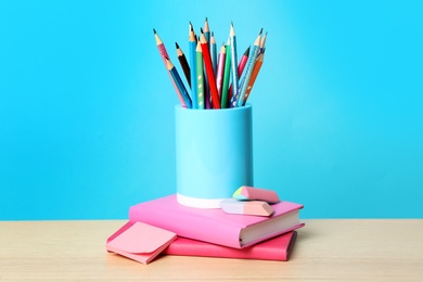 Photo of Composition with different school stationery on wooden table against light blue background. Back to school