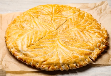 Photo of Traditional galette des rois on white wooden table, closeup
