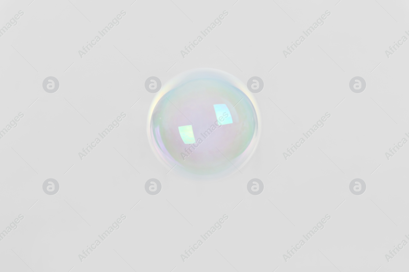 Photo of Beautiful translucent soap bubble on light background