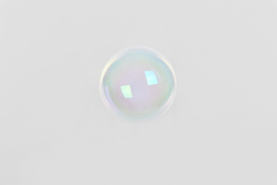 Photo of Beautiful translucent soap bubble on light background