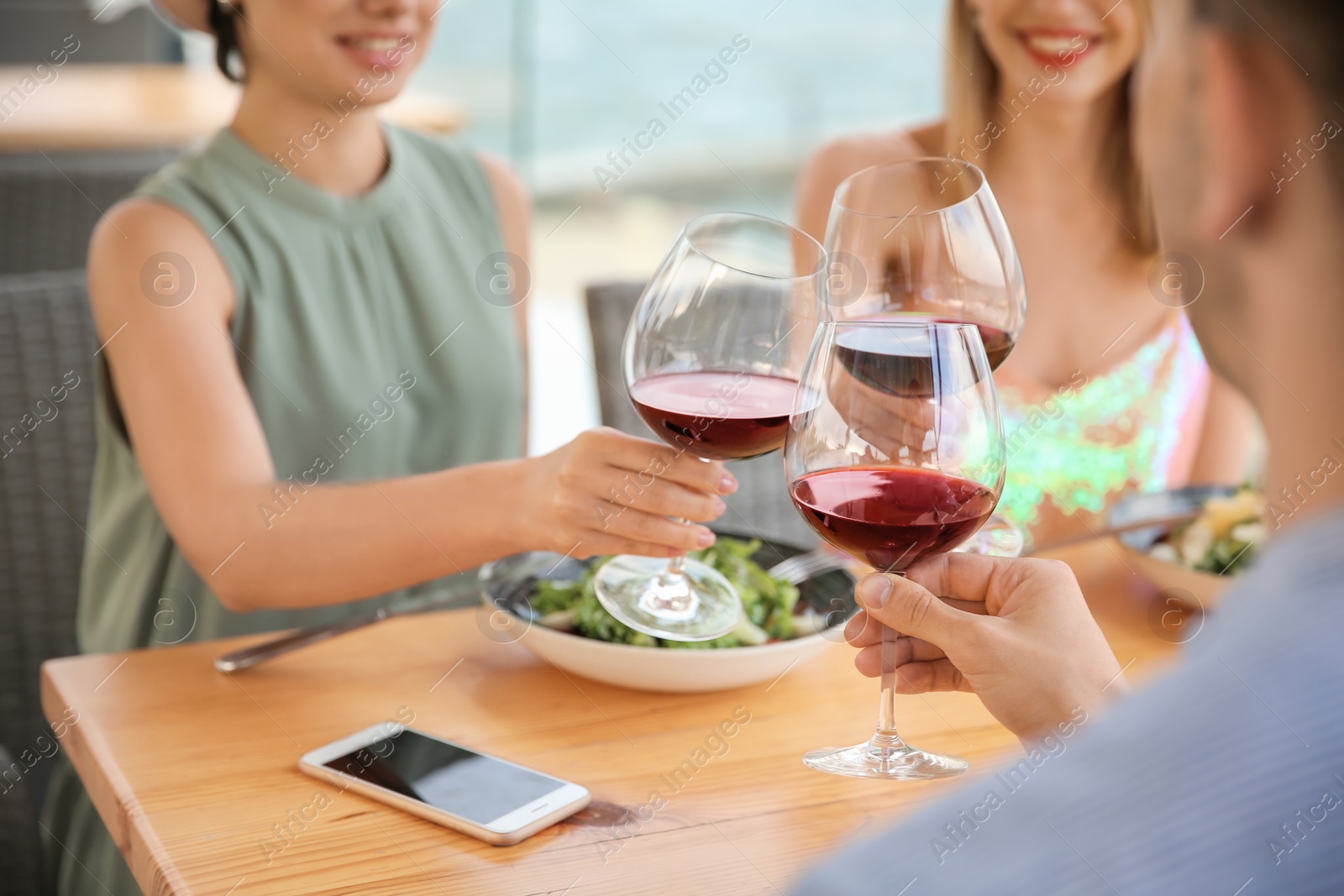 Photo of Group of friends with glasses of wine at table