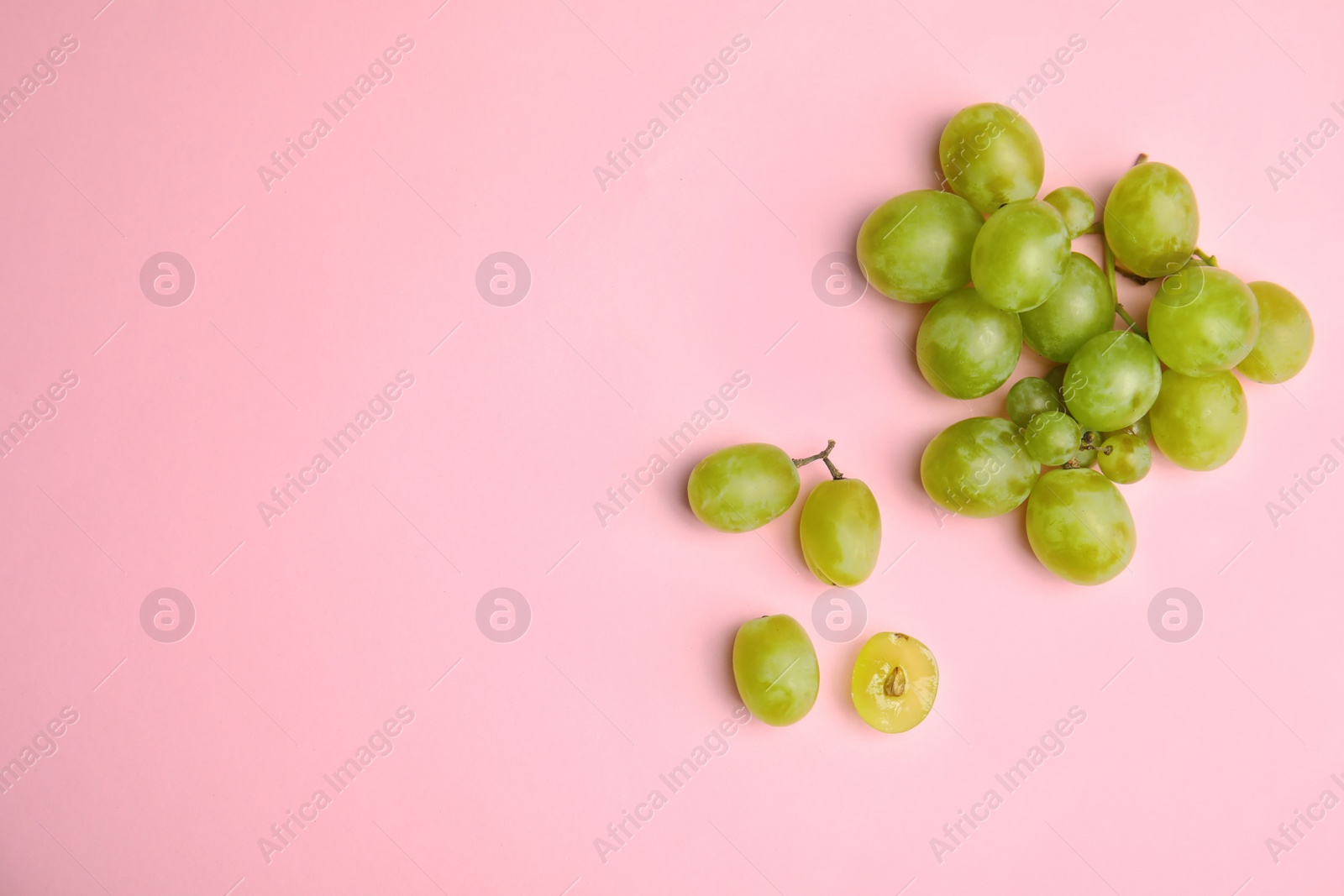 Photo of Fresh ripe juicy grapes and space for text on color background, top view