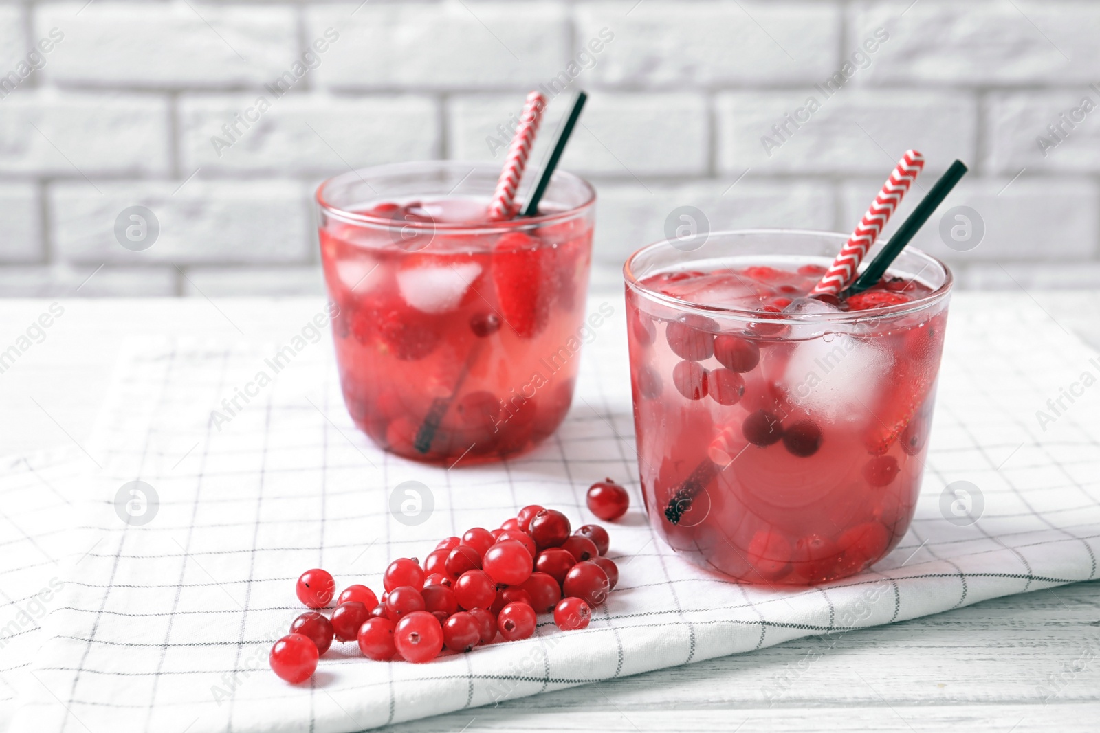 Photo of Glasses of natural lemonade with berries on table