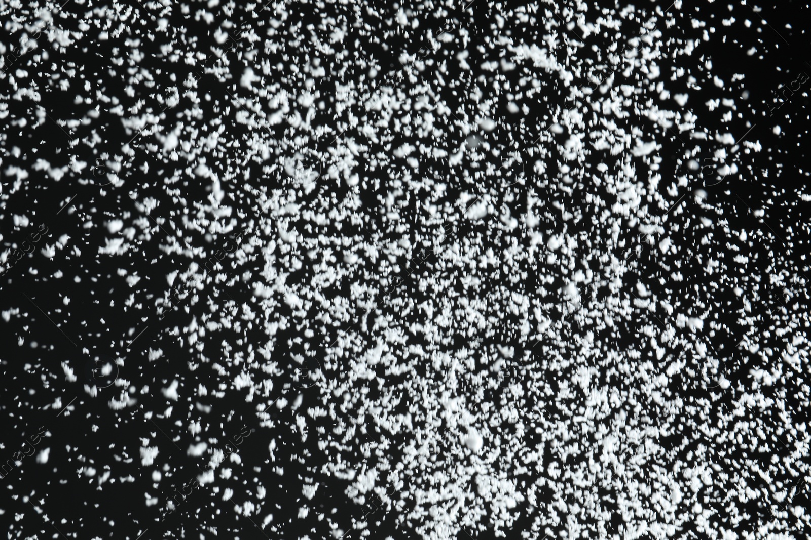 Photo of White snow falling down on black background