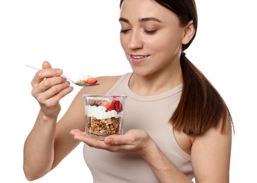 Happy woman eating tasty granola with fresh berries and yogurt on white background