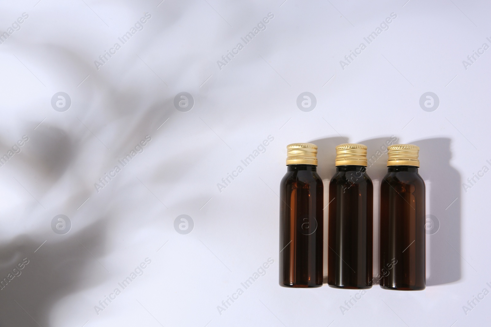 Photo of Bottles of cosmetic products on white background, flat lay. Space for text