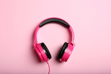 Photo of Stylish headphones on color background, top view