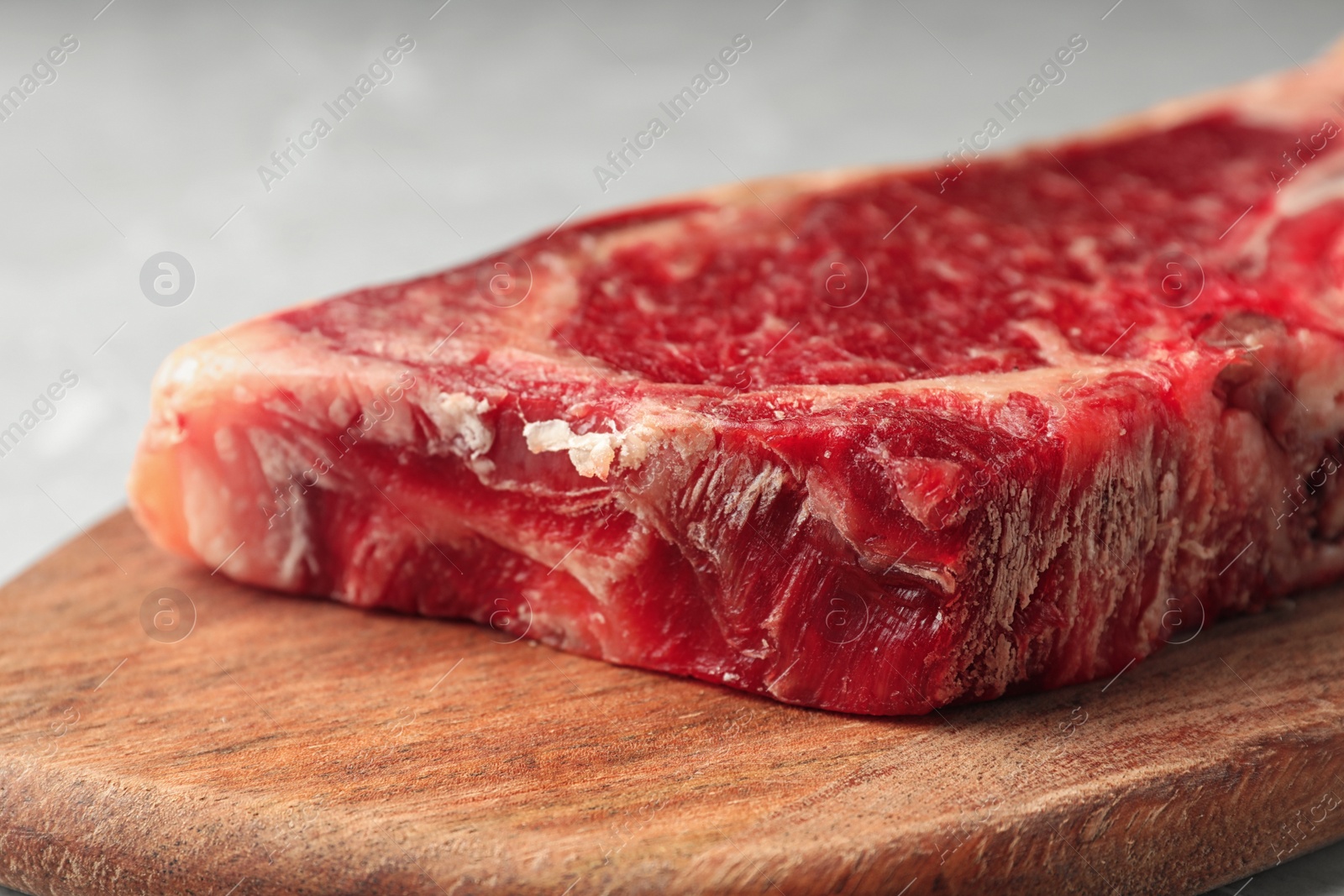 Photo of Raw beef meat on wooden board, closeup view