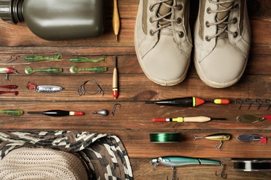Photo of Flat lay composition with fishing equipment on wooden background