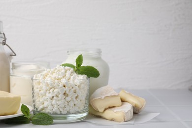 Photo of Different dairy products and mint on white table