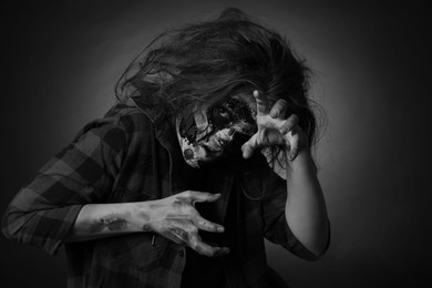 Scary zombie on dark background, black and white effect. Halloween monster