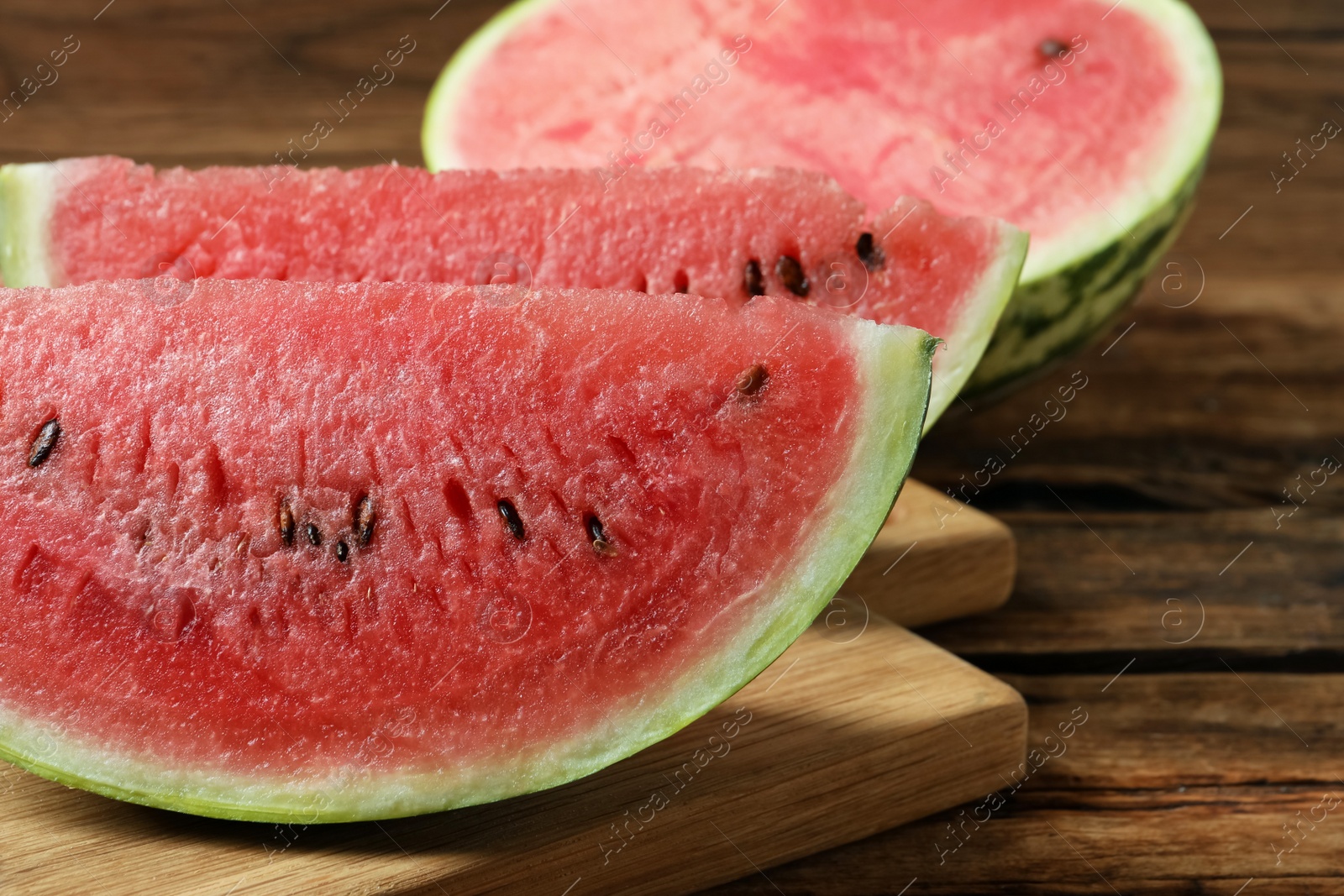 Photo of Slices of tasty ripe watermelon on wooden table, closeup