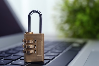 Photo of Metal code padlock on laptop keyboard, space for text. Cyber security concept