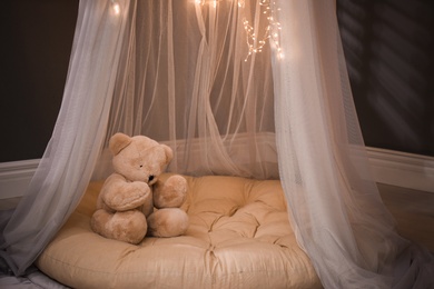 Photo of Cozy play tent with teddy bear indoors