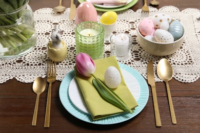 Photo of Festive table setting with painted eggs. Easter celebration