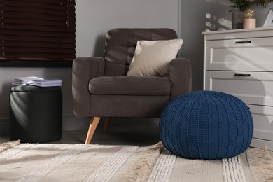 Stylish different poufs and armchair in room. Home design