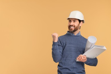Photo of Architect in hard hat with draft and folder on beige background, space for text