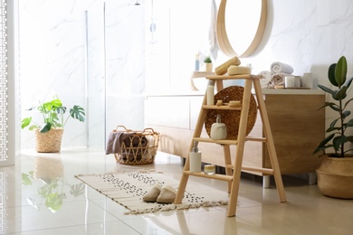 Dispensers and different toiletries on decorative ladder in bathroom. Idea for interior design