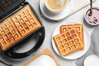 Flat lay composition with fresh Belgian waffles on light grey marble table