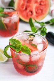 Photo of Spicy cocktail with jalapeno and mint on white wooden table