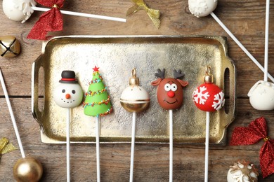 Photo of Delicious Christmas themed cake pops on wooden table, flat lay