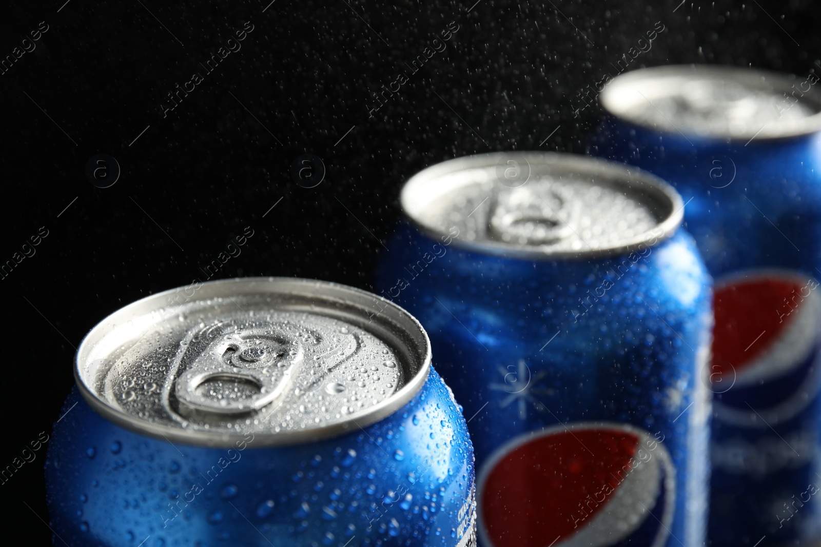 Photo of MYKOLAIV, UKRAINE - FEBRUARY 9, 2021: Cans of Pepsi on black background, closeup