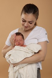 Photo of Mother with her cute newborn baby on beige background