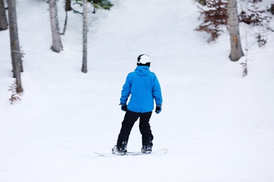 Photo of Snowboarder on slope at resort. Winter vacation