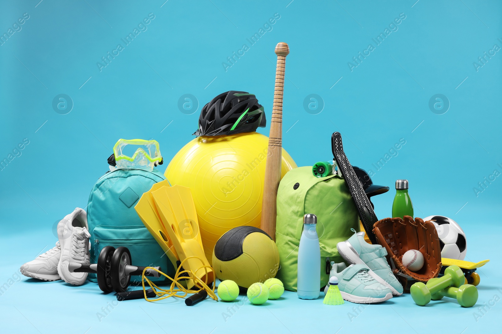 Photo of Many different sports equipment on light blue background