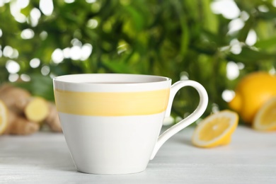 Cup of hot tea on white table, closeup