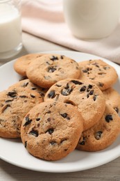 Photo of Plate with delicious chocolate chip cookies on white wooden table, closeup